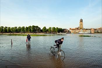 Wandelaar en fietser in ondergelopen straat in Deventer